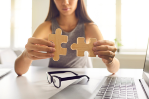 Woman putting pieces of a puzzle together to signify LMS automation